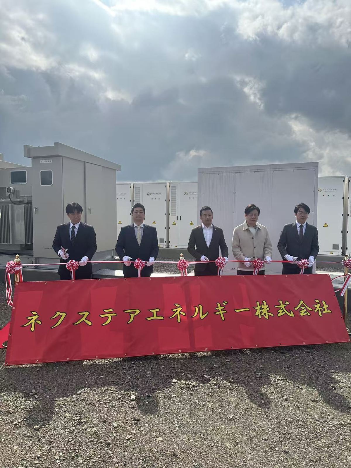 ネクステアエネルギー株式会社の社名幕を前にした竣工式のテープカット